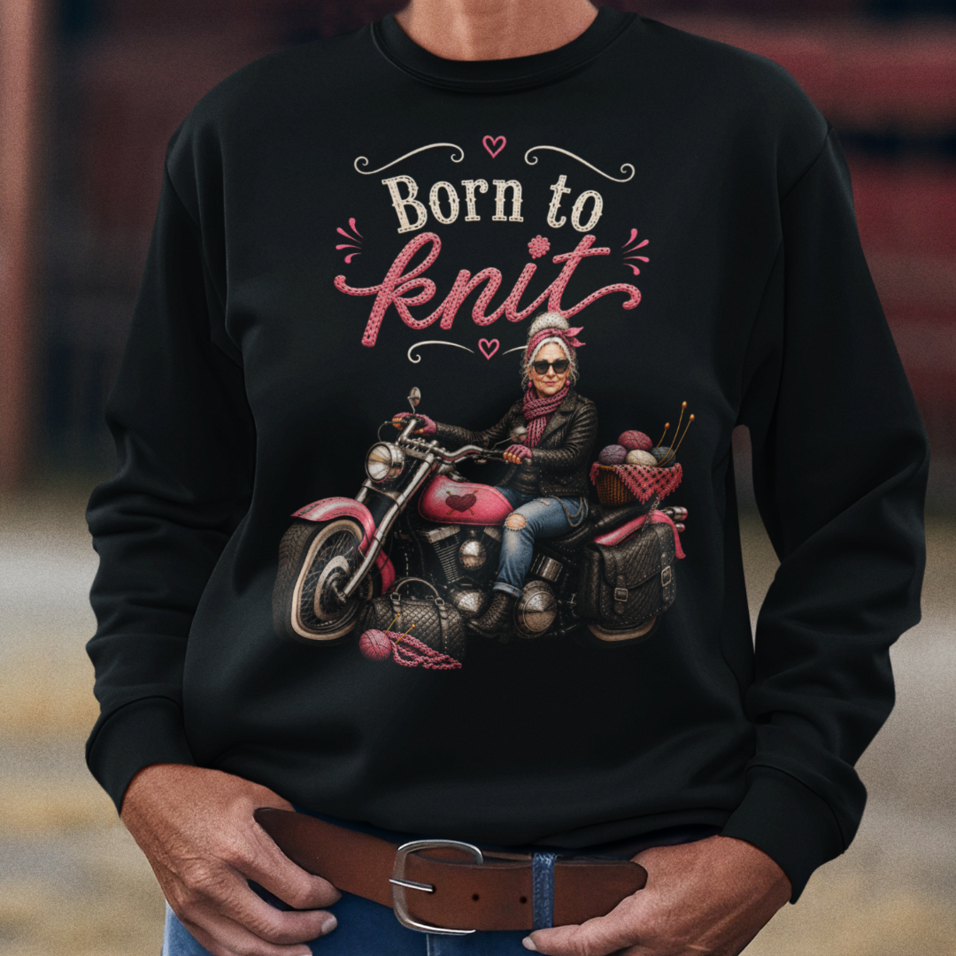 Person wearing a black sweatshirt with a graphic and text, standing in front of a barn.