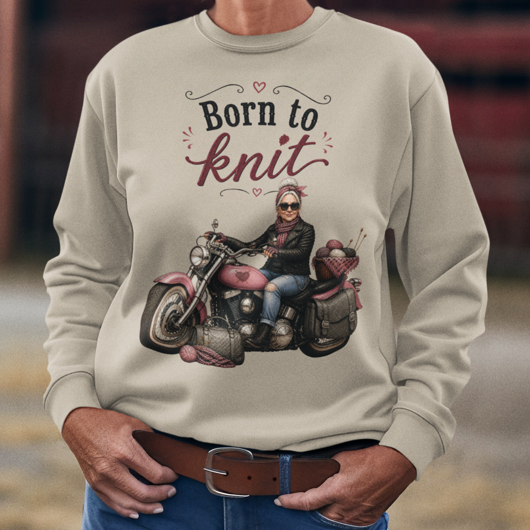 Person wearing a beige sweatshirt with a graphic and text, standing in an outdoor setting.