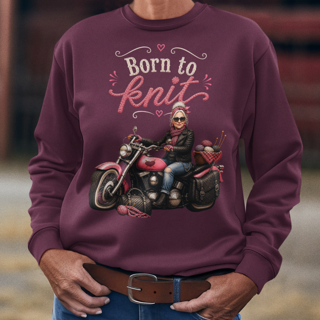 Woman wearing a maroon sweatshirt with a graphic and text, standing in an outdoor setting.
