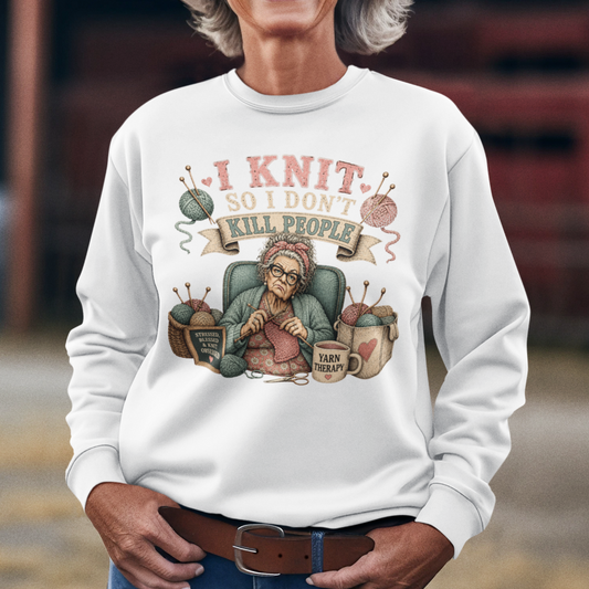 Woman wearing a white sweatshirt with a graphic design and text, standing in an outdoor setting.
