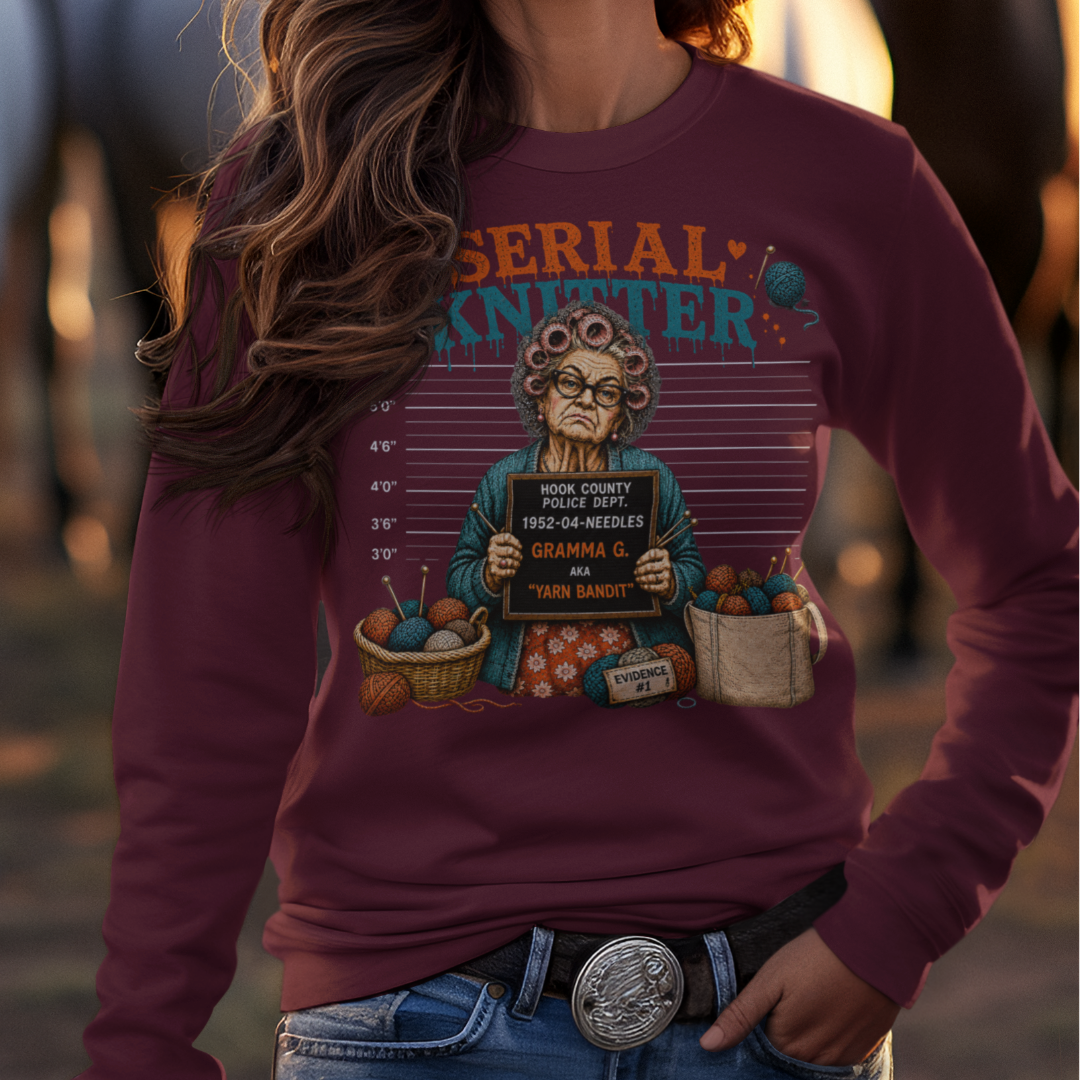 Woman wearing a cowboy hat and graphic sweatshirt with horses in the background