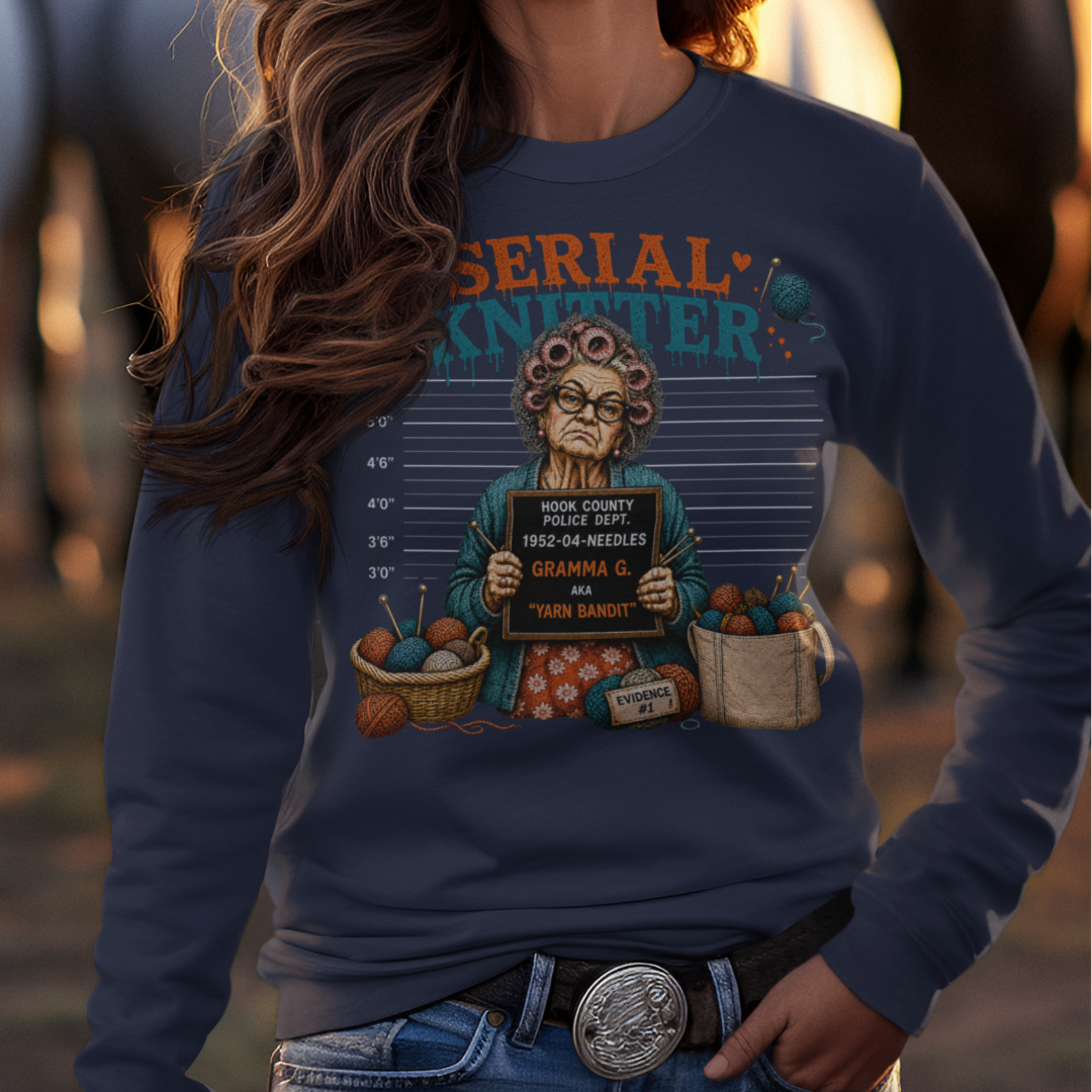 Woman wearing a cowboy hat and graphic sweatshirt with horses in the background